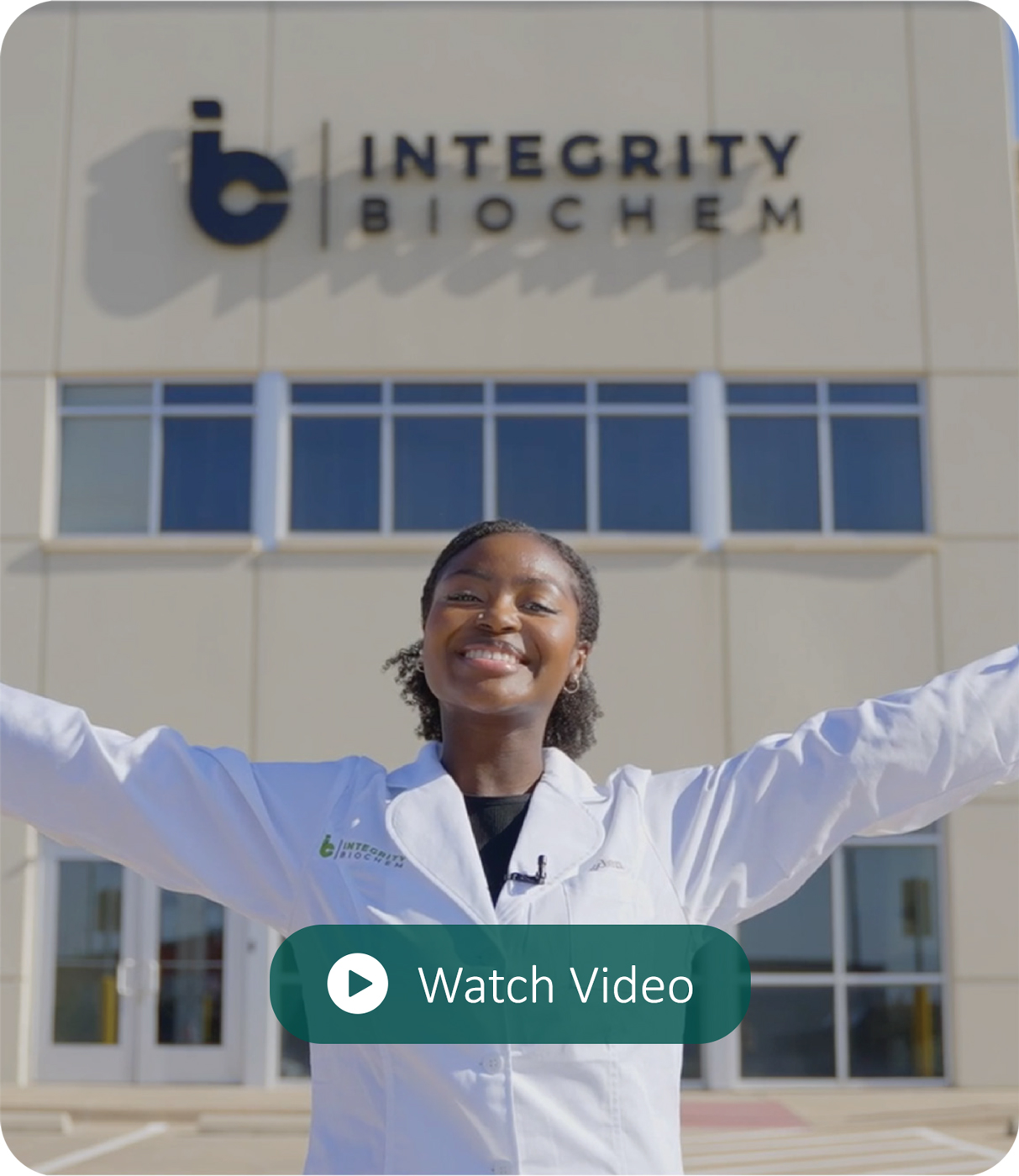 woman with arms raised in front of Integrity Biochem building